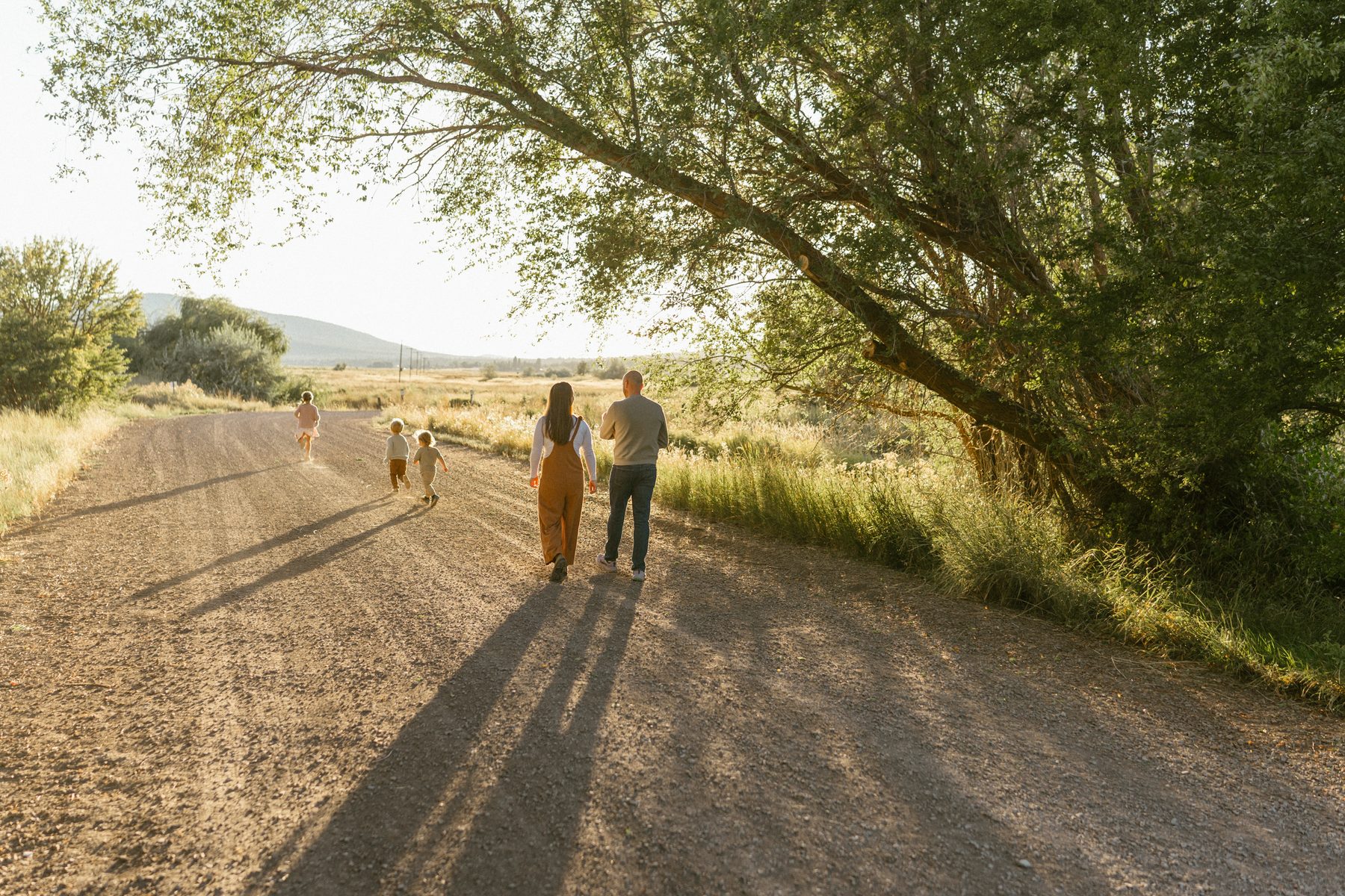 A family walking together on a sunlit road in Utah